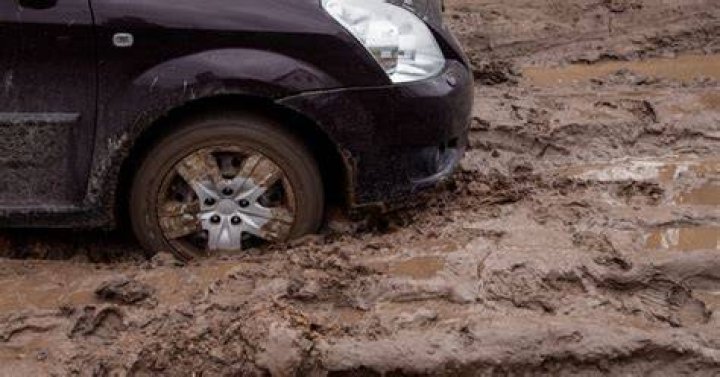A car is stuck in mud after storms hit Southern California, causing floods and mud slides