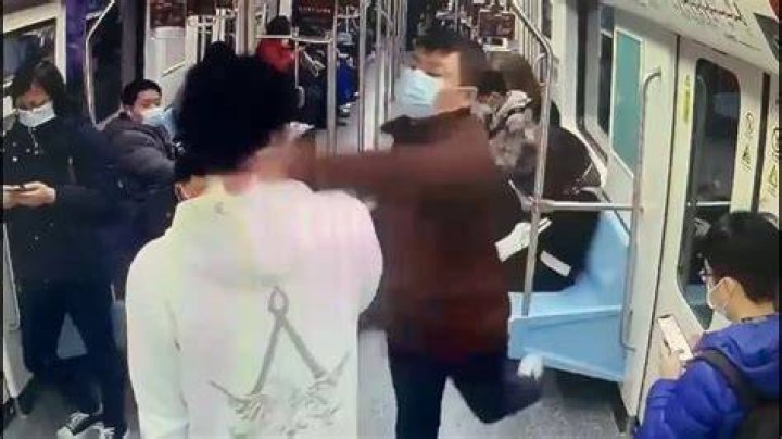 A subway passenger (right) punches another rider (left) after coming to the defense of a customer who was elbowed in the face by the man he got into the fight with