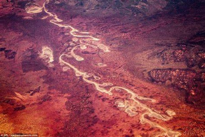 Aerial photos show the red-roofed home with a bright white facade still in seemingly pristine condition, against the grey-toned, ashen landscape by which it is surrounded
