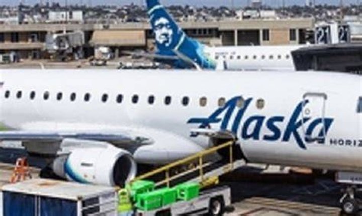 An off-duty Alaska Airlines pilot accused of trying to crash a plane with 84 people on board has been pictured for the first time - as stunned locals on his street described him as the perfect dad, husband and neighbor. (Pictured: Joseph Emerson with wife Sarah Stretch)