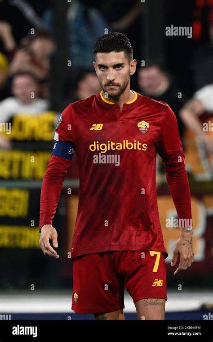Lorenzo Pellegrini holds a Roma scarf aloft as he takes in the scenes during the bus parade
