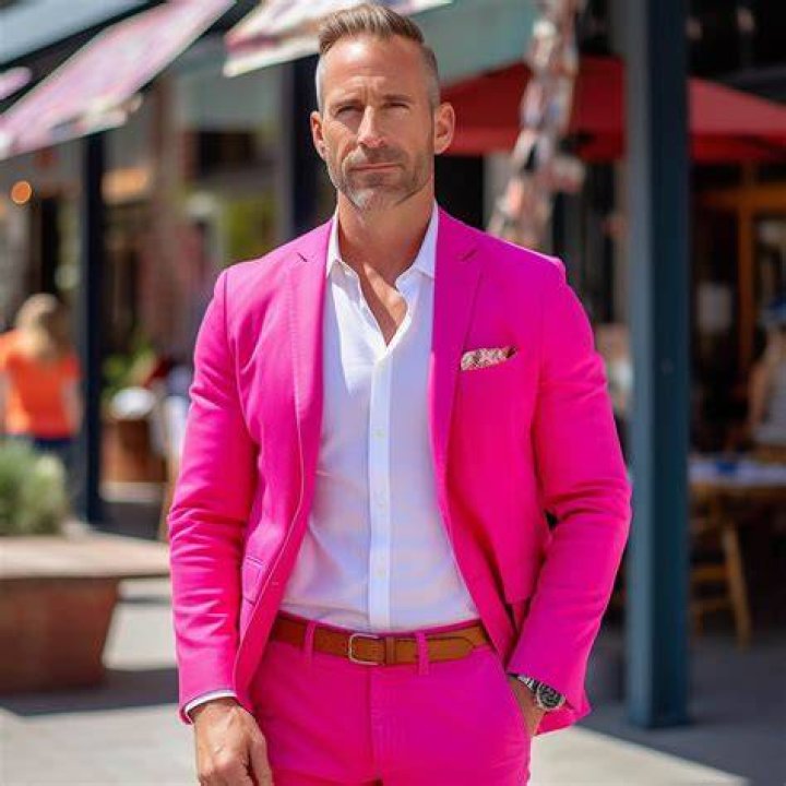The man in pink was caught on camera pulling on the woman's braids and punching her mercilessly in front of their own family members and bystanders in the presence of children