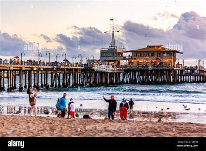 Tourists are pictured in Santa Monica during the storm in Los Angeles, CA, on Monday